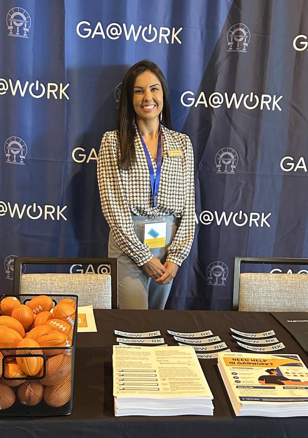 Picture or woman at GA@WORK expo table. 